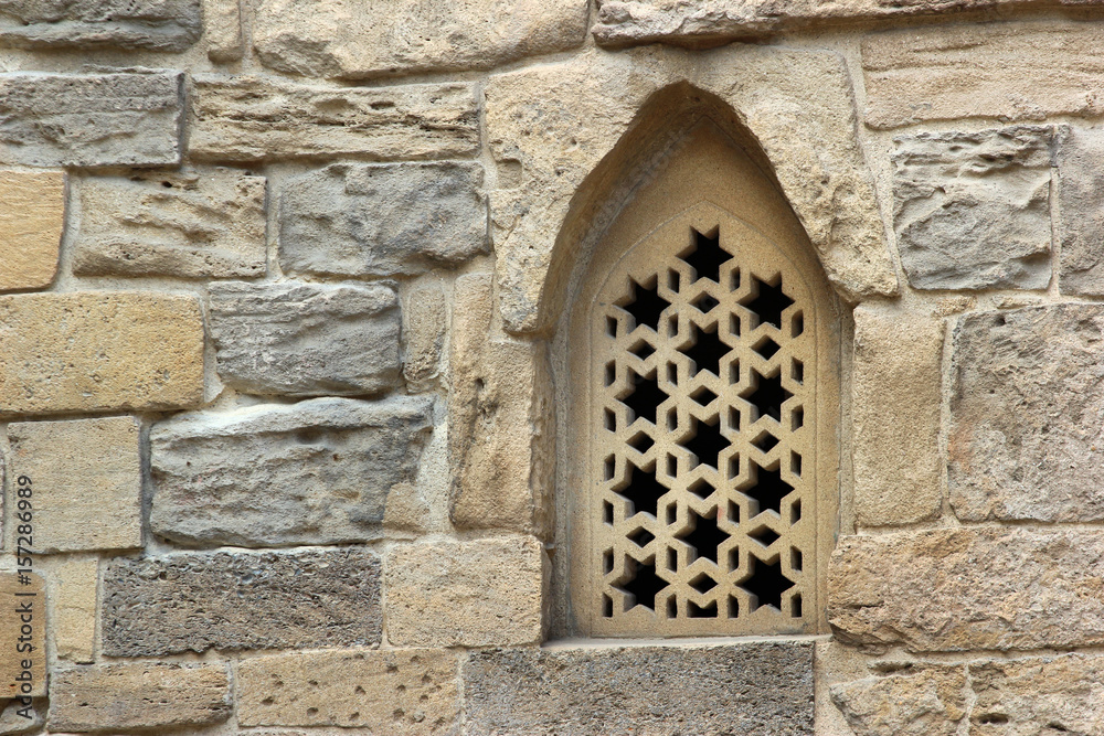 Arched window in stone wall of an old mosque, Baku, Azerbaijan