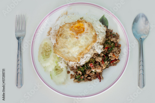 Basil Pork with Egg with Cutlery on wood white color.