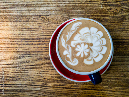 Hot mocha coffee or capuchino in the green cup with luxury pattern on the wooden table