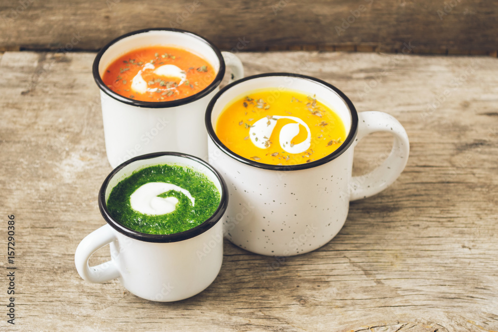 Homemade vegetarian soup made from fresh spinach pumpkin  tomatoes poured into a white mug