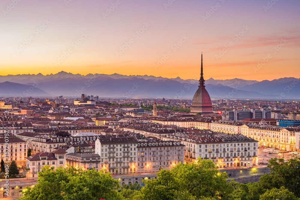 Cityscape of Torino (Turin, Italy) at dusk with colorful moody sky. The Mole Antonelliana towering on the illuminated city below.