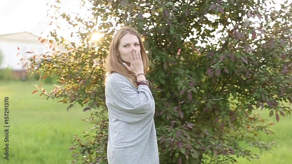 In the field young attractive girl sending a love kiss In the field young attractive girl sending a love kiss
