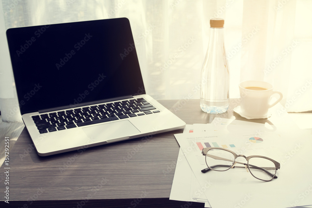 wood office table with business information paper, modern glasses and hot coffee on white drape in living room.
