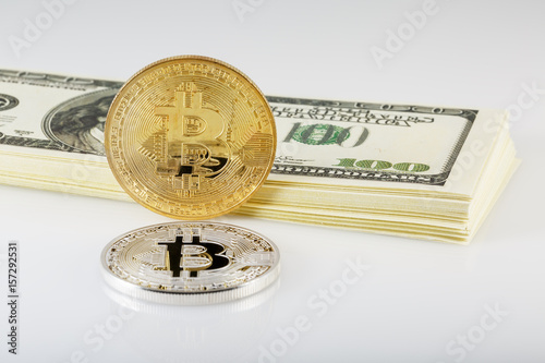 Золотой и серебряный биткоин на фоне пачки долларов