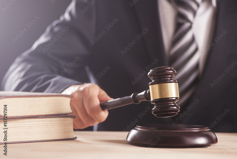 Gavel in the hand of a man in a business suit Gavel in the hand of a man in a business suit