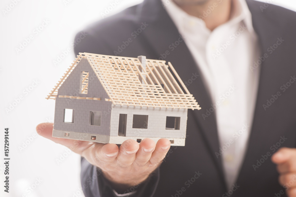Businessman Holding Model House In Palm Of Hand Businessman Holding Model House In Palm Of Hand