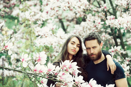 woman hugging bearded man at magnolia trees © Volodymyr