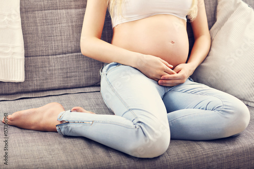 Happy pregnant woman resting on sofa