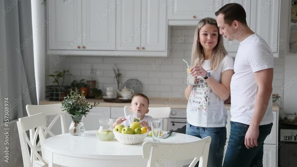 Happy young family having Breakfast in the kitchen. Healthy food. Bright interior Happy young family having Breakfast in the kitchen. Healthy food. Bright interior