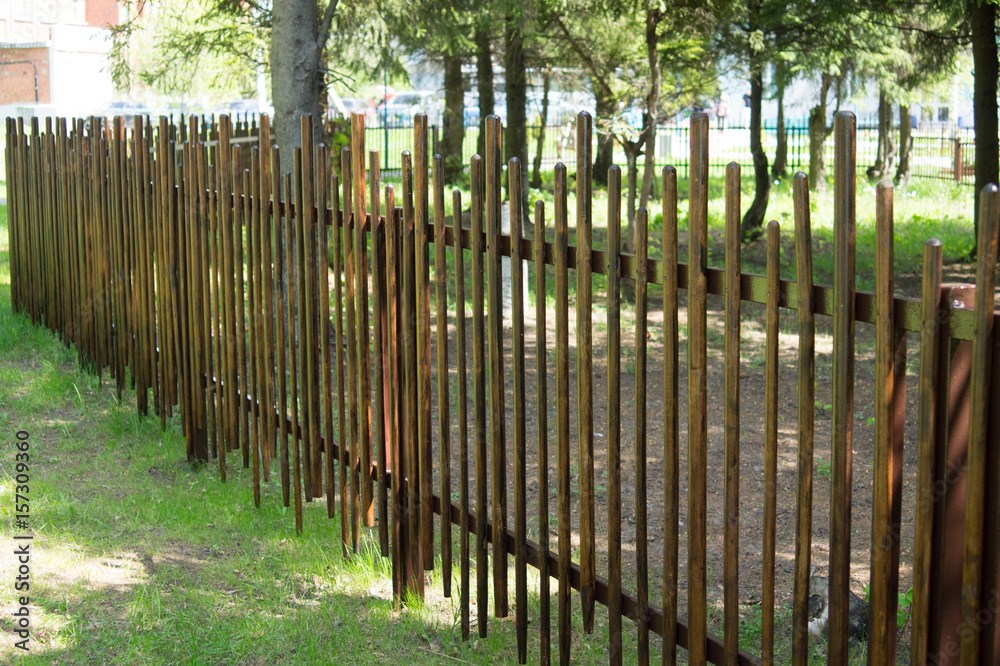Wooden fence of sticks and rods. A hedge of branches. Texture and background.