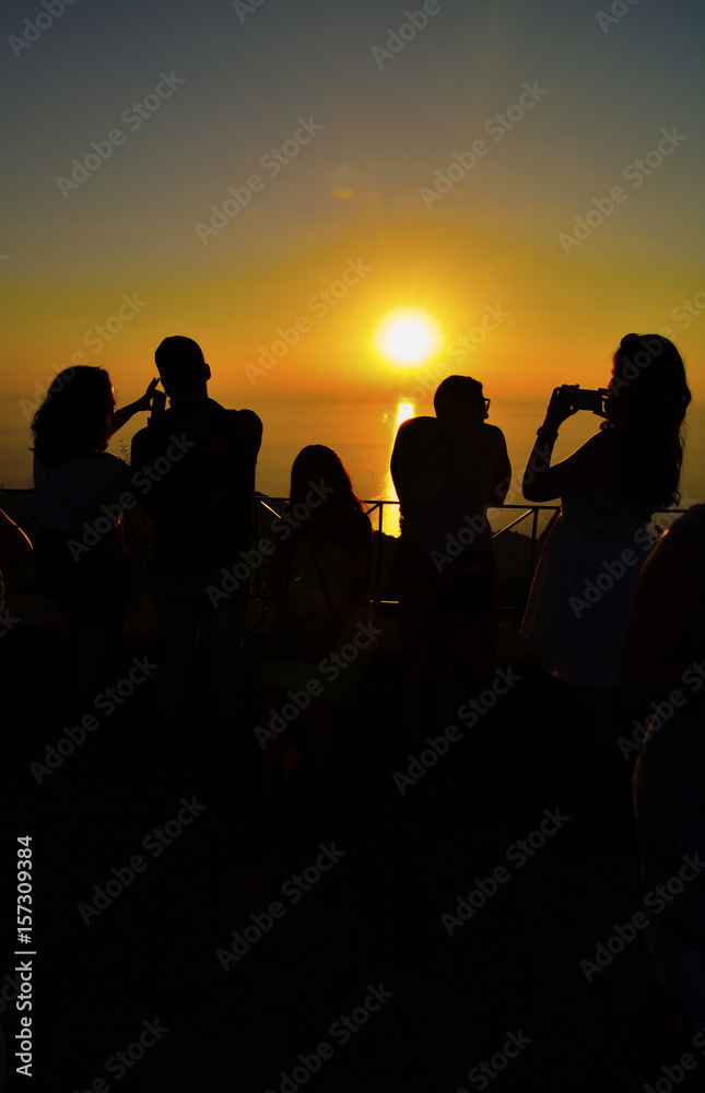 Tourists photographing sunset