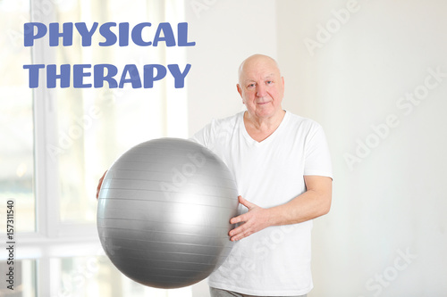 Senior man with fitball in ...