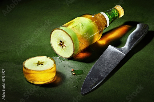 Cider.Apple cider. Bottle of cider.Creative shot cutted bottle with cider and apple inside. Advertising shot photo