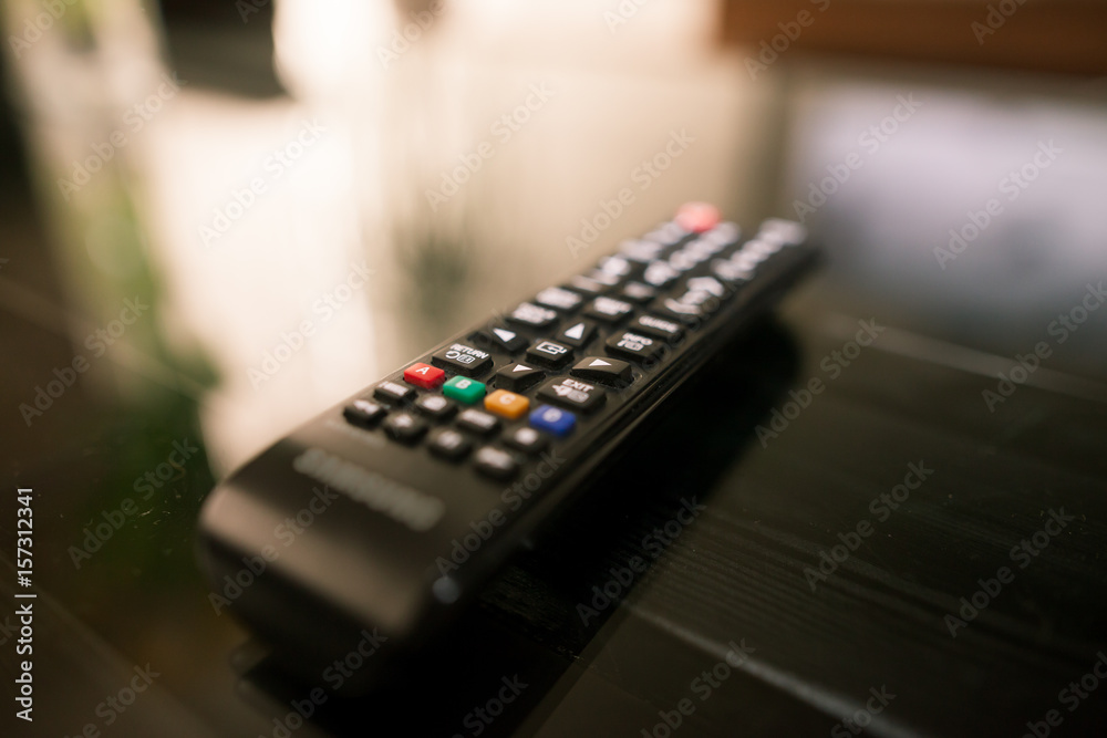 Close-up TV remote of smart television on the glass table at living room Close-up TV remote of smart television on the glass table at living room