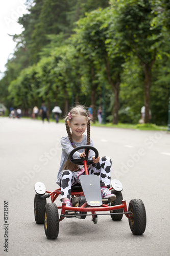 Little girl in racing car amusemant park photo