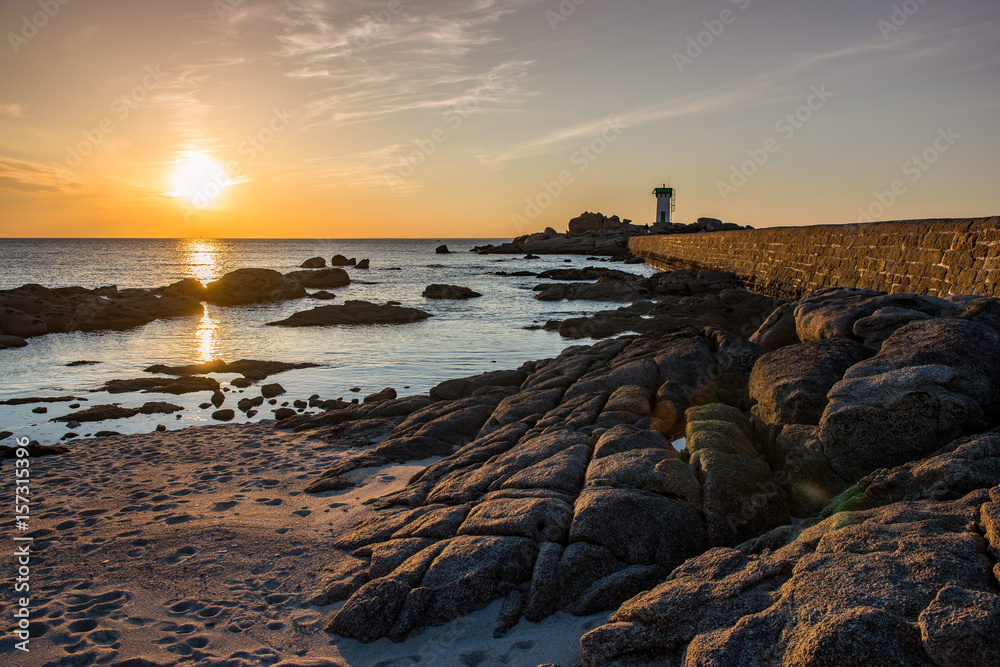 Rocky coast and lighthouse in Trevignonat sunset, Brittany