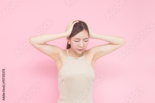 Korean woman feelong headache, isolated with pink background.