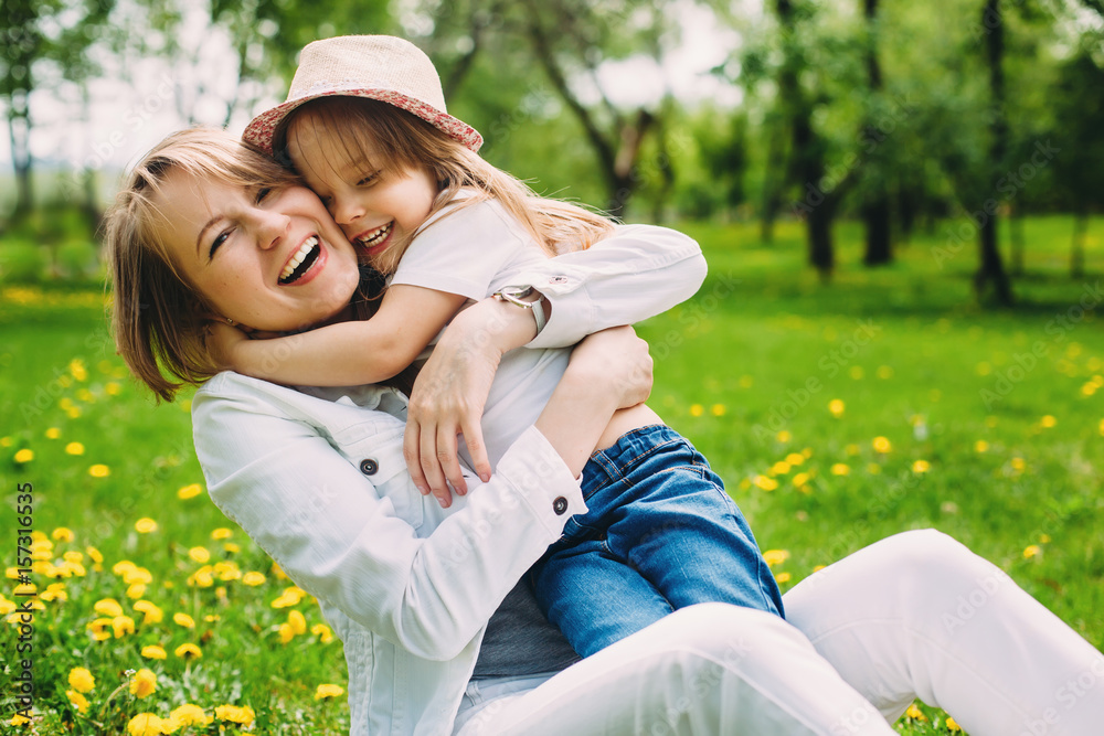 hugging happy mother and daughter for a walk in the park On the green lawn hugging happy mother and daughter for a walk in the park On the green lawn