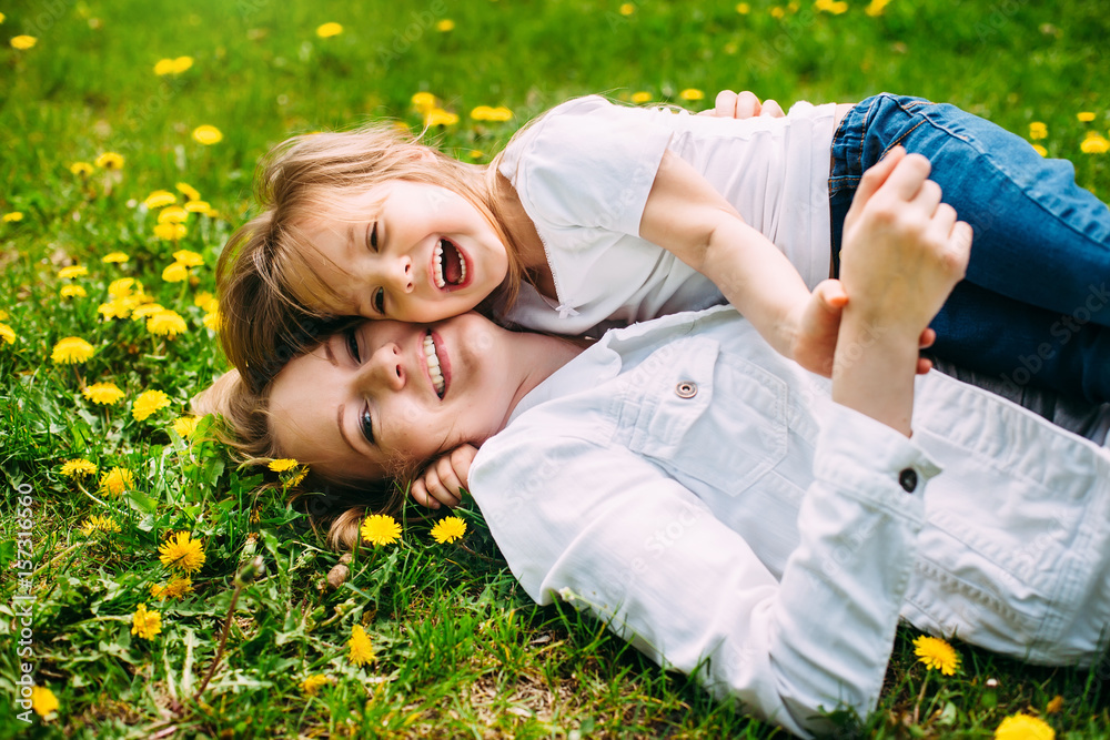 hugging happy mother and daughter for a walk in the park On the green lawn hugging happy mother and daughter for a walk in the park On the green lawn