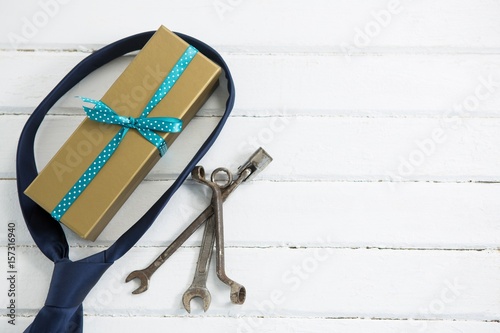 Overhead view of gift box with necktie and hand tools