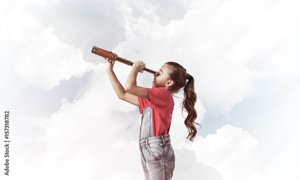 Concept of careless happy childhood with girl looking in spygl Concept of careless happy childhood with girl looking in spygl