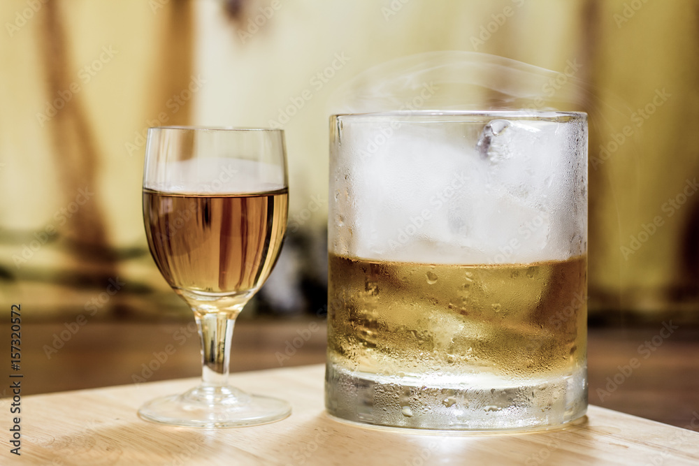 Whiskey shot glass & full tumbler with smoke & ice Whiskey shot glass & full tumbler with smoke & ice