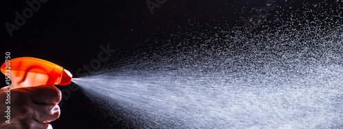 woman spraying liquid cleaner