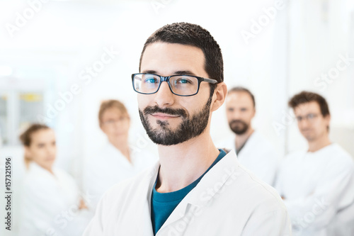 Ricercatore in laboratorio, uomo con camice e team  photo