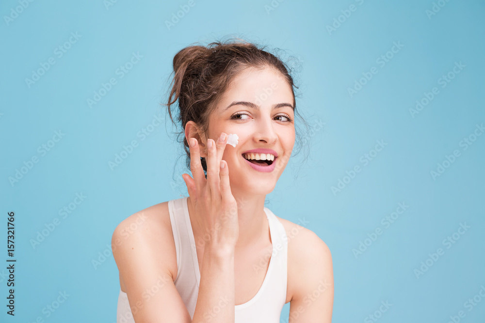 Woman with cream on blue background Woman with cream on blue background