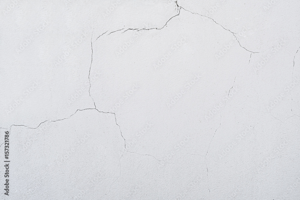 On the wall a lot cracks on a beige plaster On the wall a lot cracks on a beige plaster