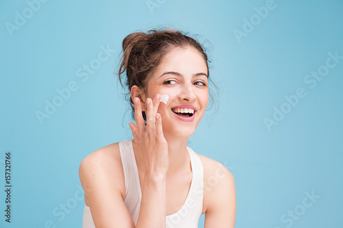 Woman with cream on blue background