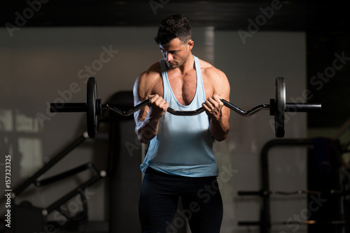 Biceps Exercise With Barbell in a Fitness Center