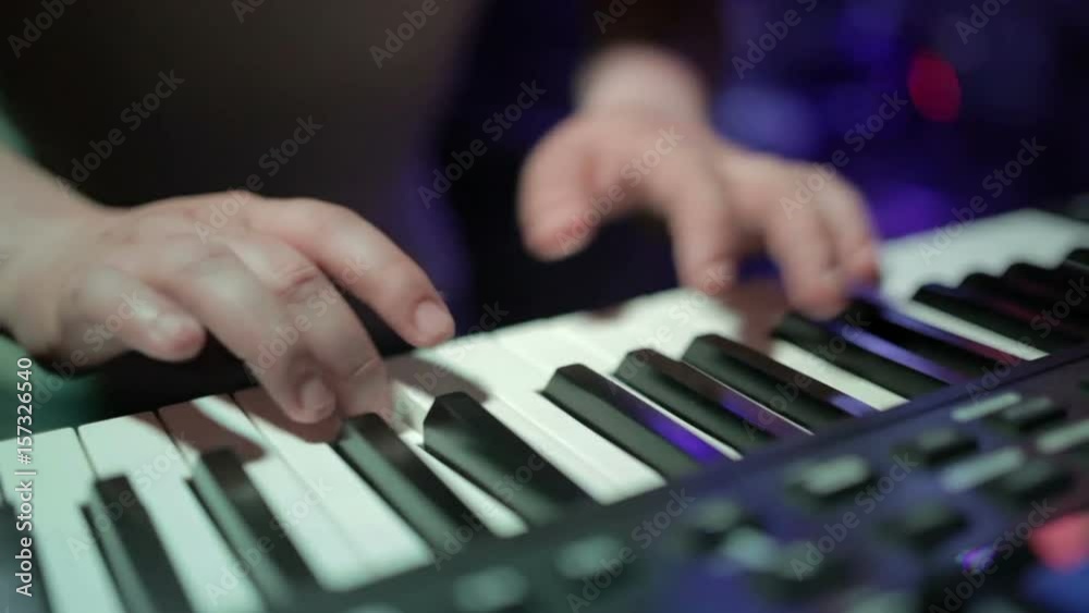 Musician playing on the keyboard synthesizer piano keys. Musician plays a musical instrument on the concert stage