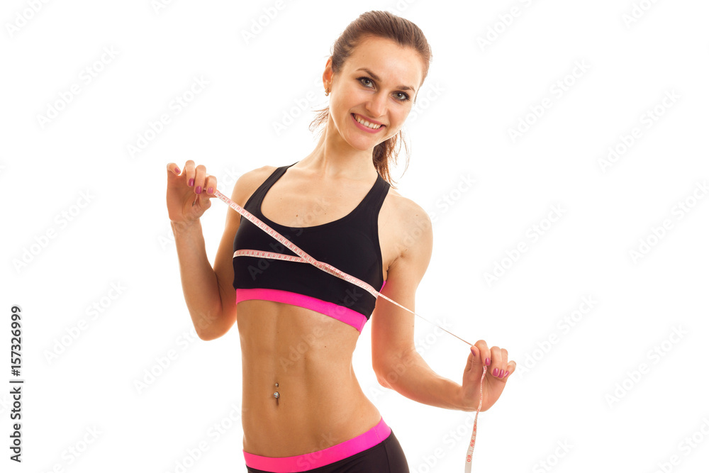 Cheerful young sports woman with measure tape smiling on camera Cheerful young sports woman with measure tape smiling on camera