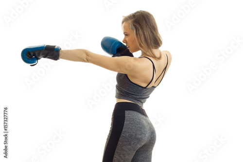 Young blonde girl practicing boxing in blue gloves © ponomarencko