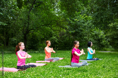Beautiful smiling woman doing yoga in the park.