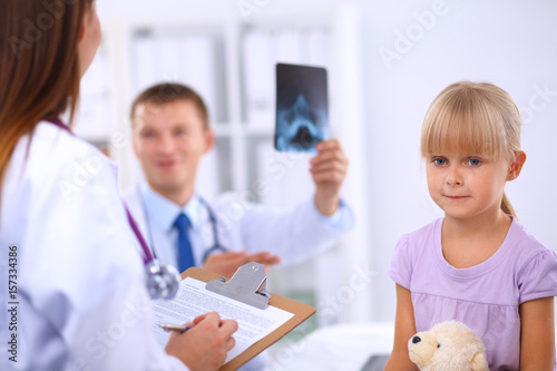Female doctor examining child with stethoscope at surgery