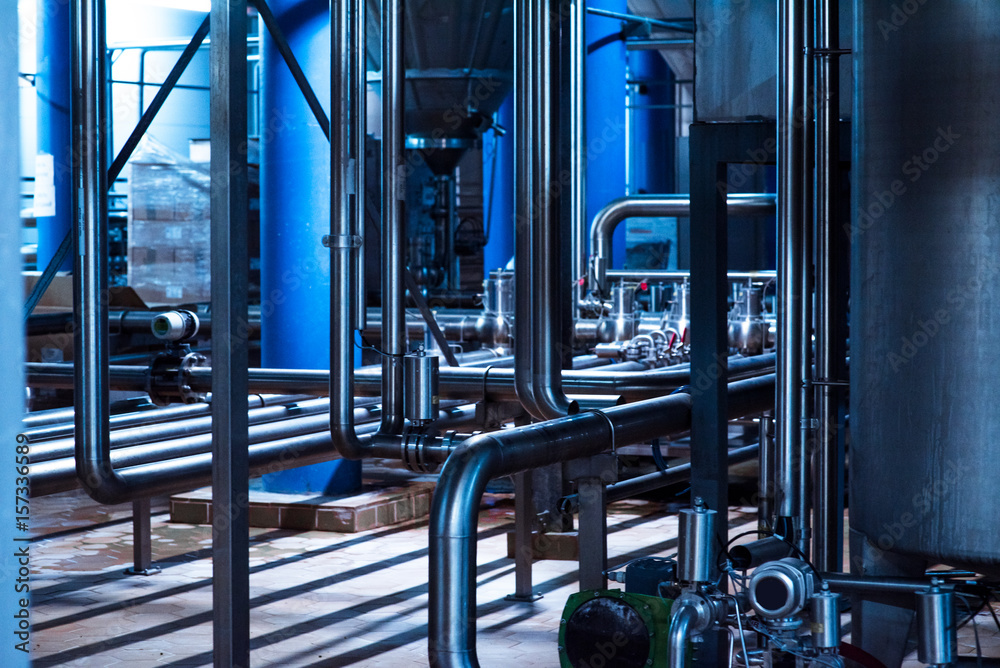 Modern beer plant brewery , with brewing kettles, vessels, tubs and pipes made of stainless steel.