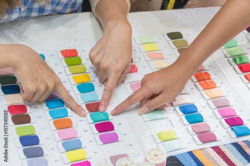 Close up hands of fashion designers are choosing fabric colors.