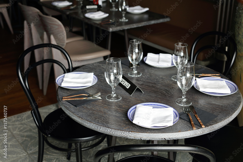 Reserved sign on restaurant table with empty dishes and glasses Reserved sign on restaurant table with empty dishes and glasses