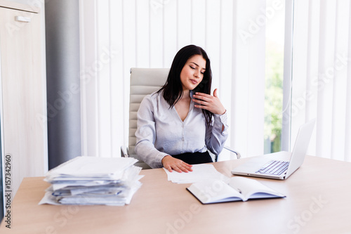 Businesswoman sitting in office and working with some documents photo