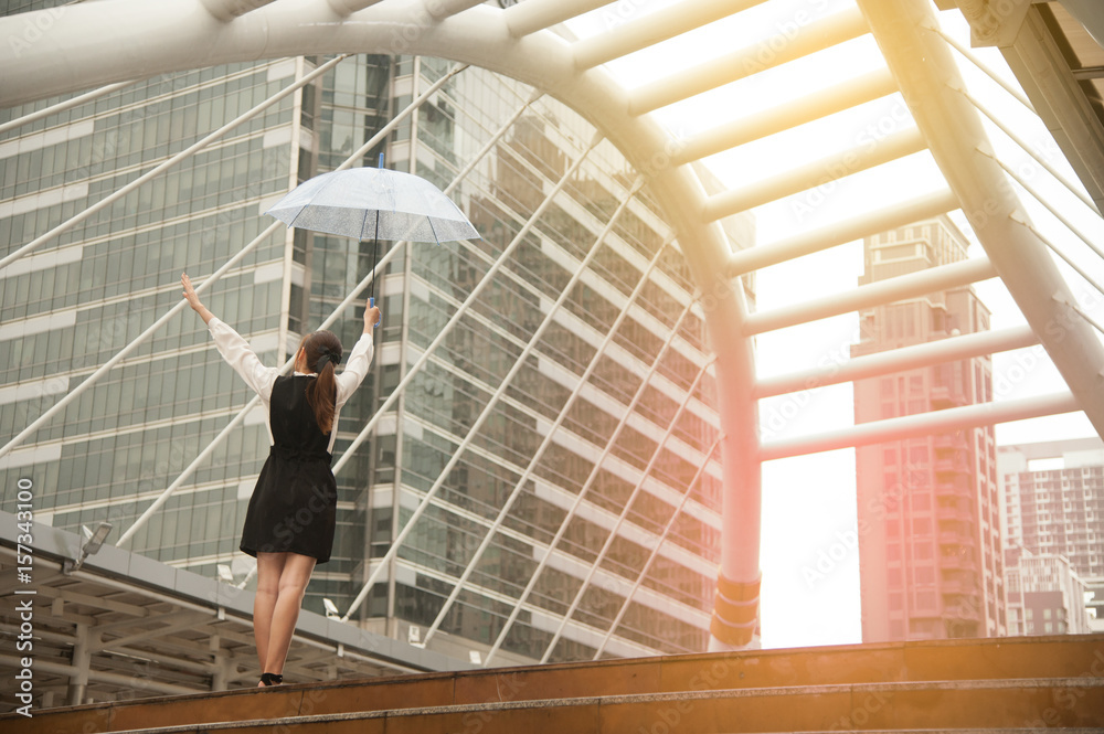 Thai pretty woman in black dress holding transparent umbrella walking on bridge crossing landmark in Bangkok,Thailand. Thai pretty woman in black dress holding transparent umbrella walking on bridge crossing landmark in Bangkok,Thailand.