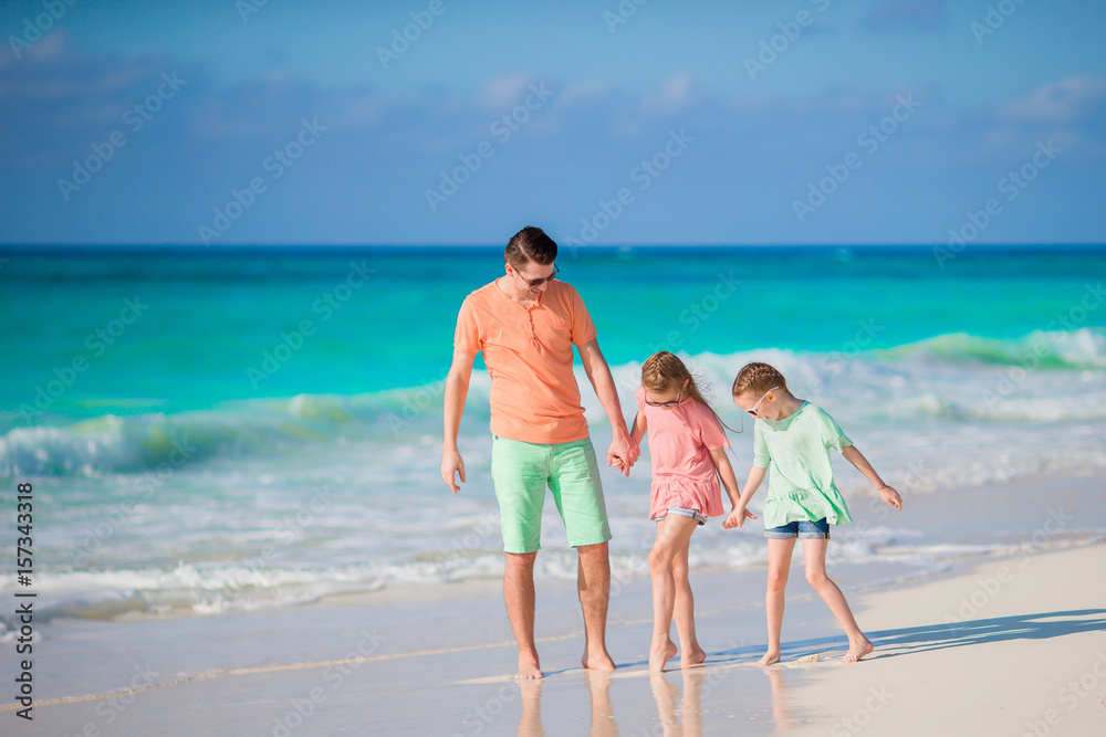 Family of dad and kids on white tropical beach have a lot of fun