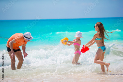 Canvas Print Little girls and happy dad having fun during beach vacation