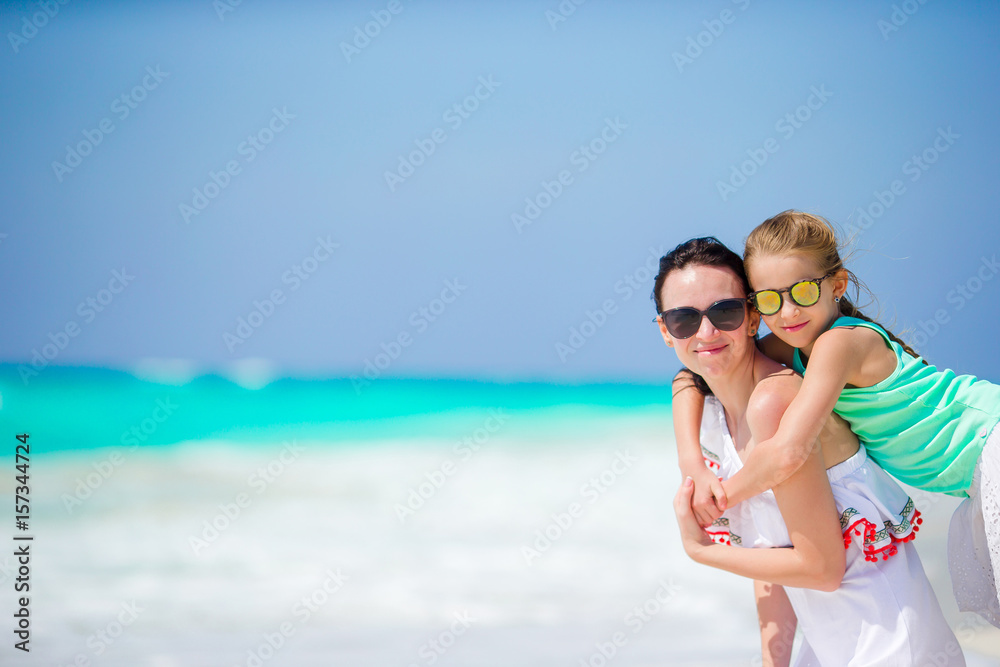 Little adorable girl and young mother at tropical beach Little adorable girl and young mother at tropical beach