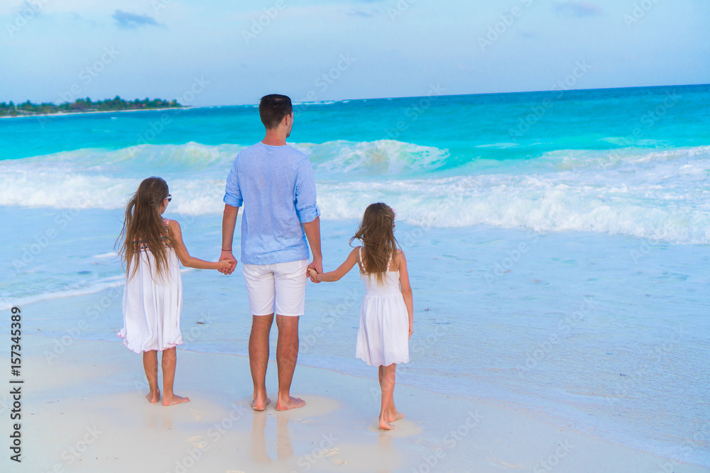 Family of dad and kids walking on white tropical beach on caribbean island Family of dad and kids walking on white tropical beach on caribbean island