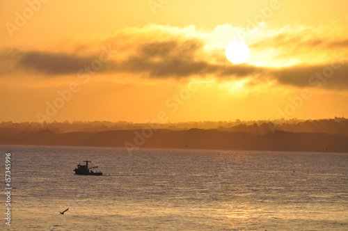 foggy sunset fisherman leaves the bay
