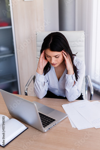 Businesswoman having headache in her office after doing very hard work