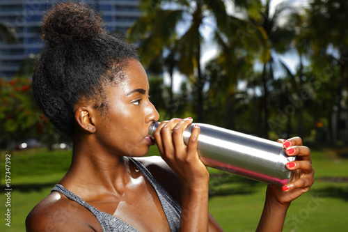 Fitness model posing with a water bottle in the park