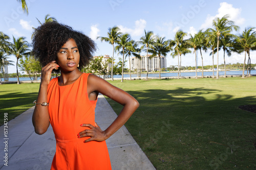 Photography Woman posing in a fashionable orange dress in the park